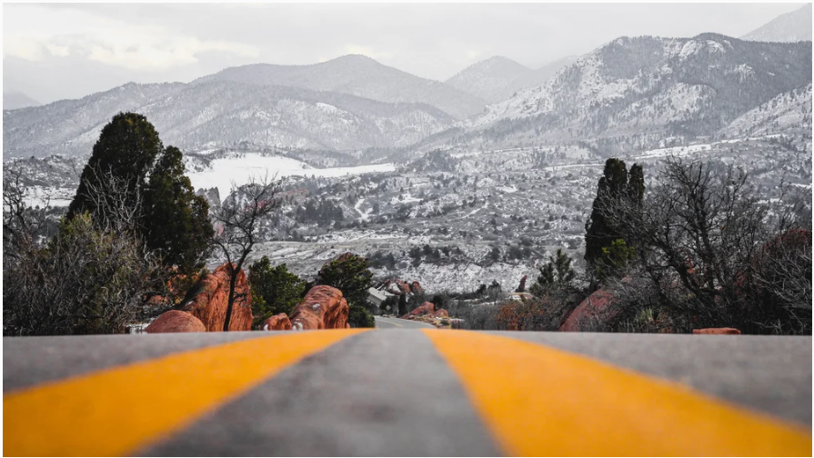 Mountain road winding through snowy Colorado peaks